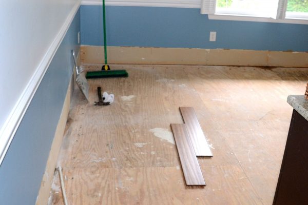 Putting down new flooring after ripping up the old floor during a DIY renovation remodeling project.