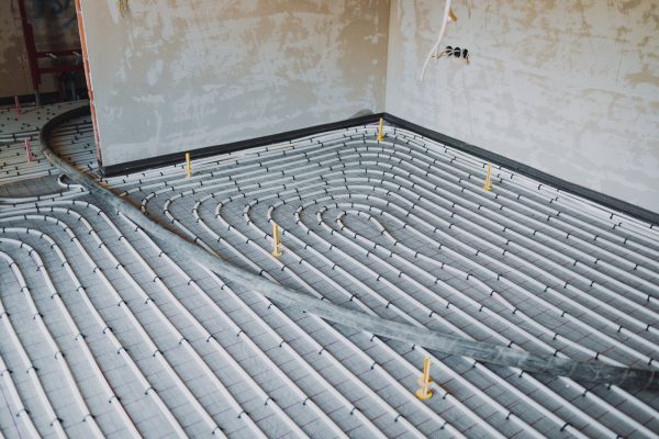 Underfloor heating system installation with concrete surface flooring